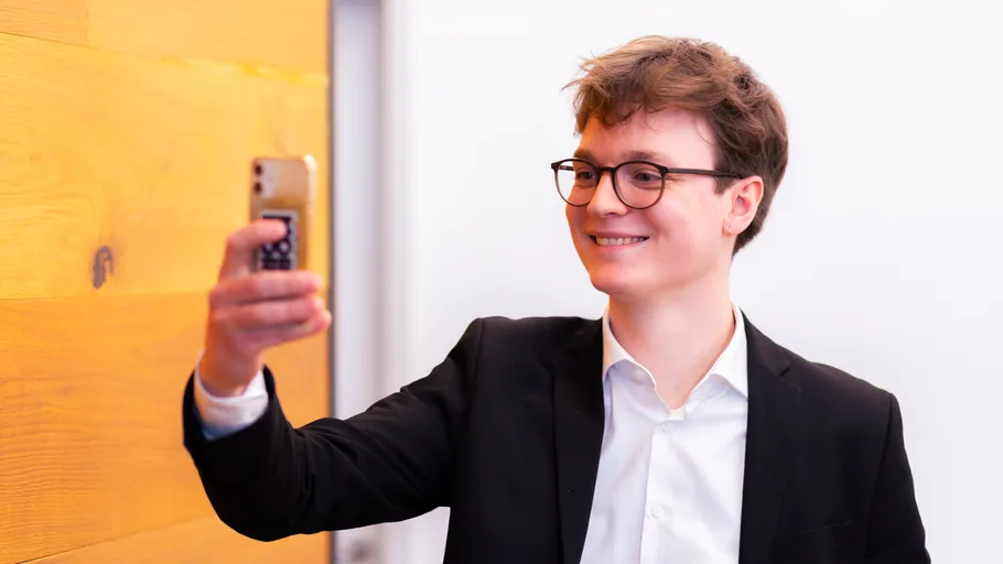 Man taking a selfie with a smartphone indoors.