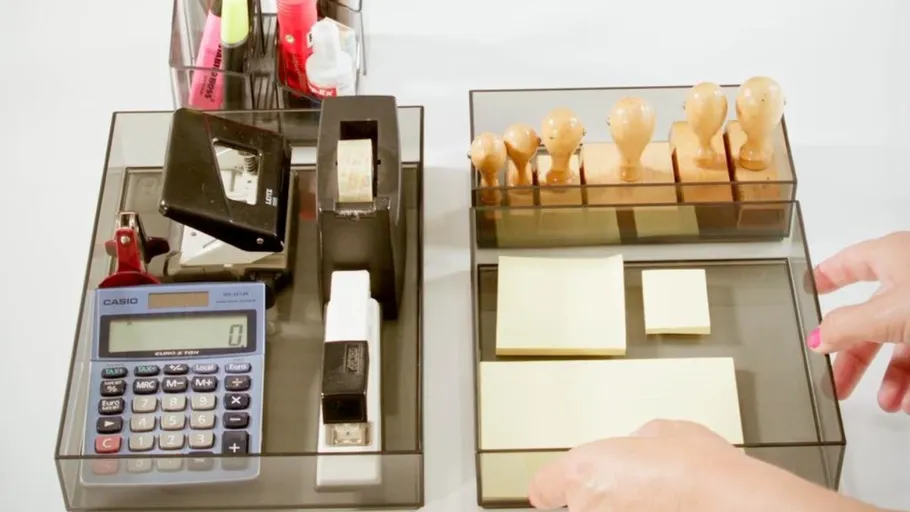 Office supplies organized in transparent trays.