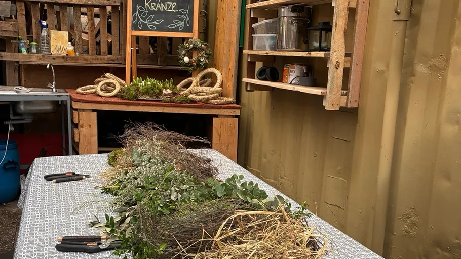 Table with natural wreath materials in workshop.