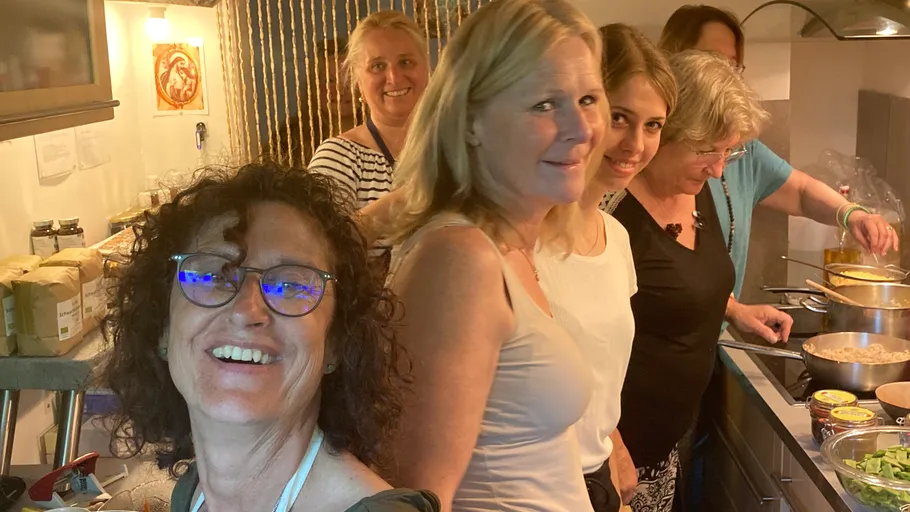 Group of women cooking in a kitchen.