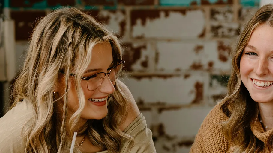 Two women smiling in an indoor setting.