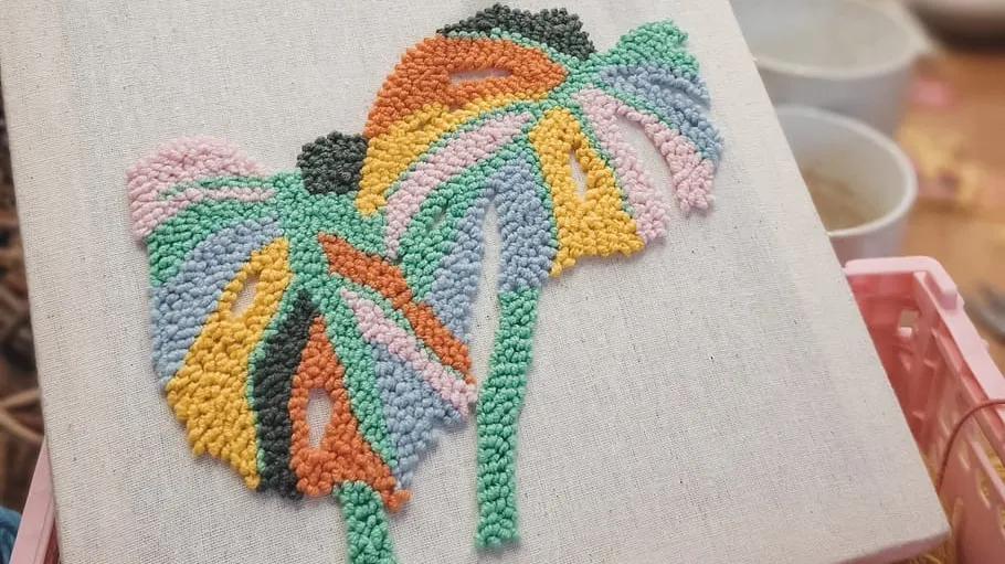 Colorful punch needle art on canvas indoors.