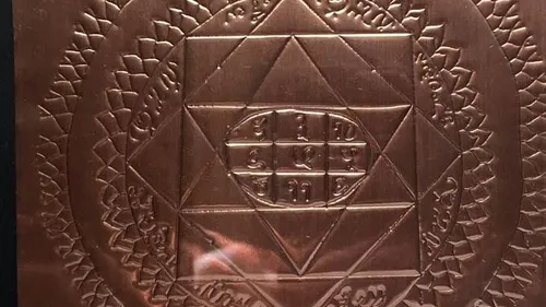 Engraved copper plate with geometric design.