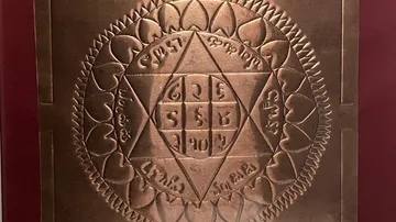 Copper plate with engraved geometric design.