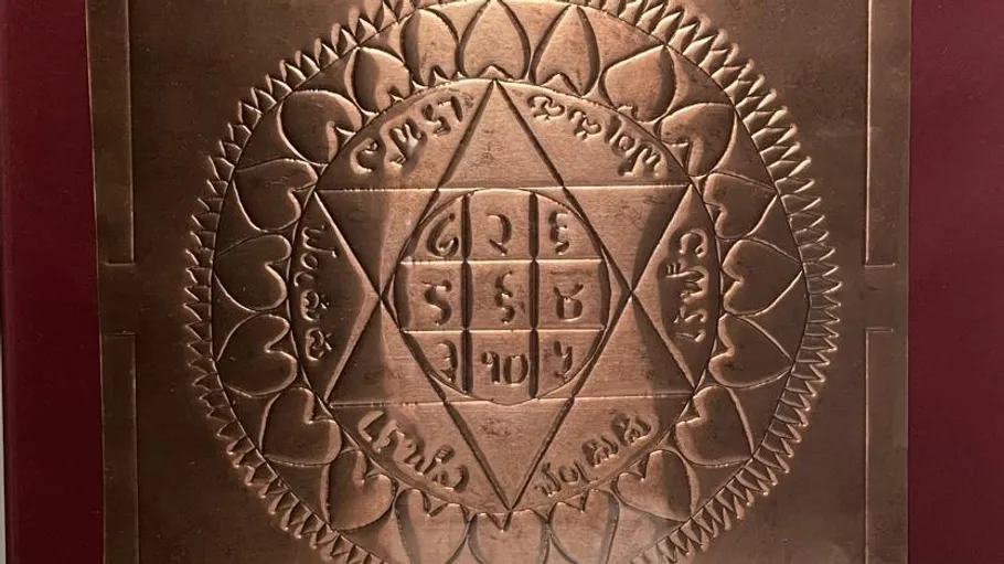 Copper plate with engraved geometric design.