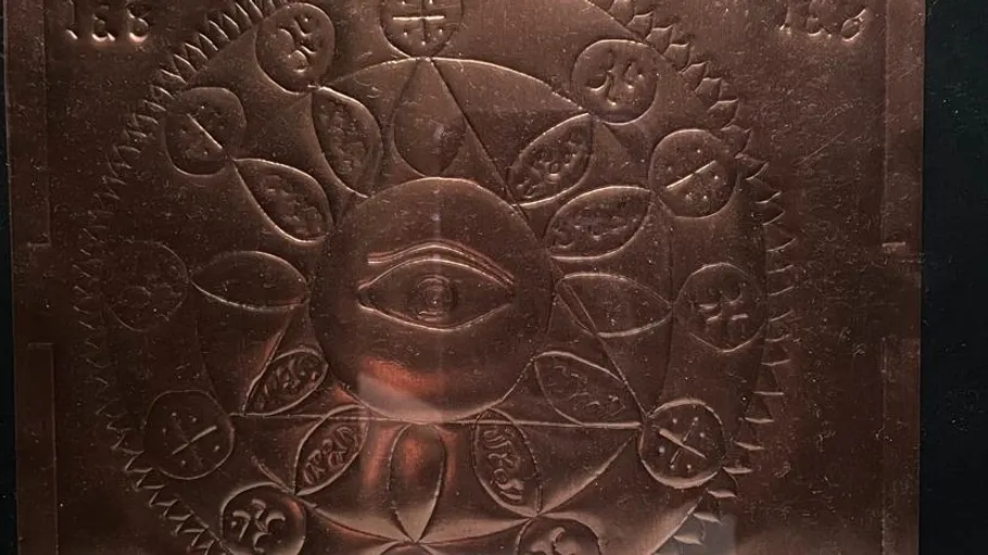 Copper plate with eye and engraved symbols.