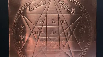 Engraved copper plate with intricate symbols and grid.