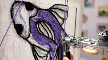 Tufting-Pistole erstellt violettes Schmetterlingsmuster.