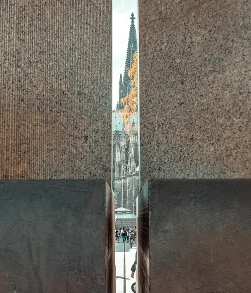 Cathedral spire viewed through narrow gap.