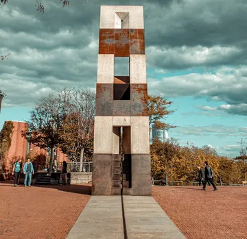 Hohe Skulptur auf Ziegelweg stehend.