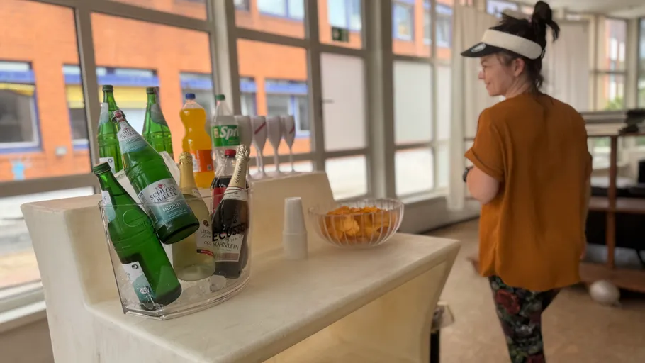 Woman near a table with drinks and snacks.