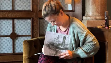 Frau liest ein Buch in gemütlicher Umgebung.