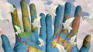 Hands with world map and doves flying.