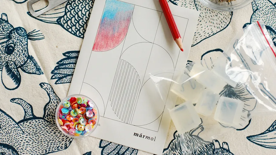 Bunte Pailletten auf Papier mit rotem Bleistift.