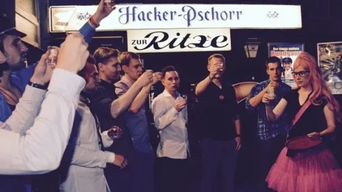 Group toasting outside bar at night.