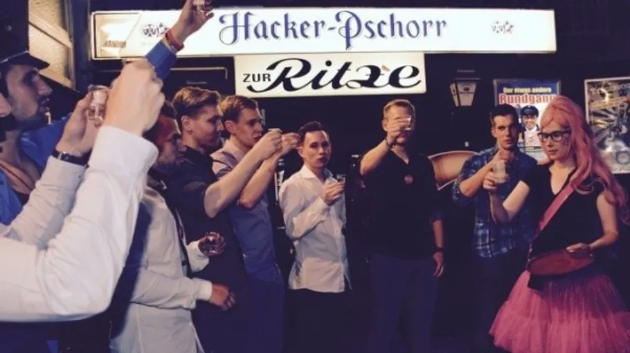 Group toasting outside bar at night.
