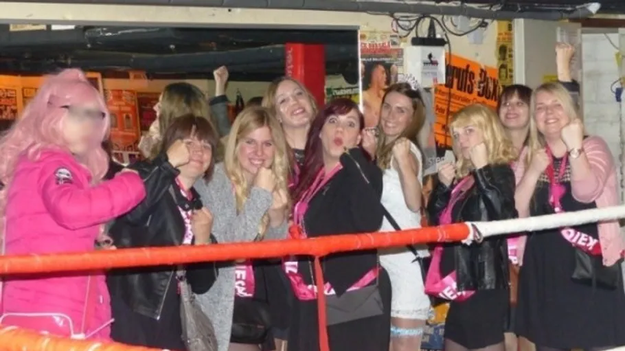 Group of women posing inside a boxing ring.