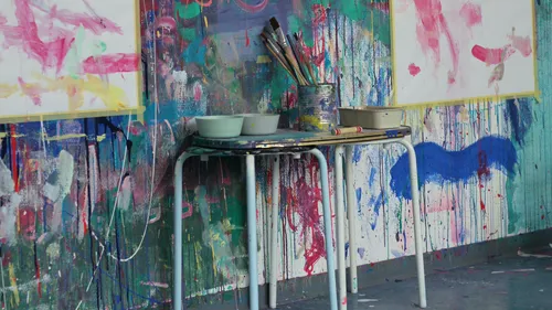 Kunstbedarf auf Tisch in buntem Studio.