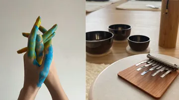 Painted hands intertwined beside bowls and kalimba.
