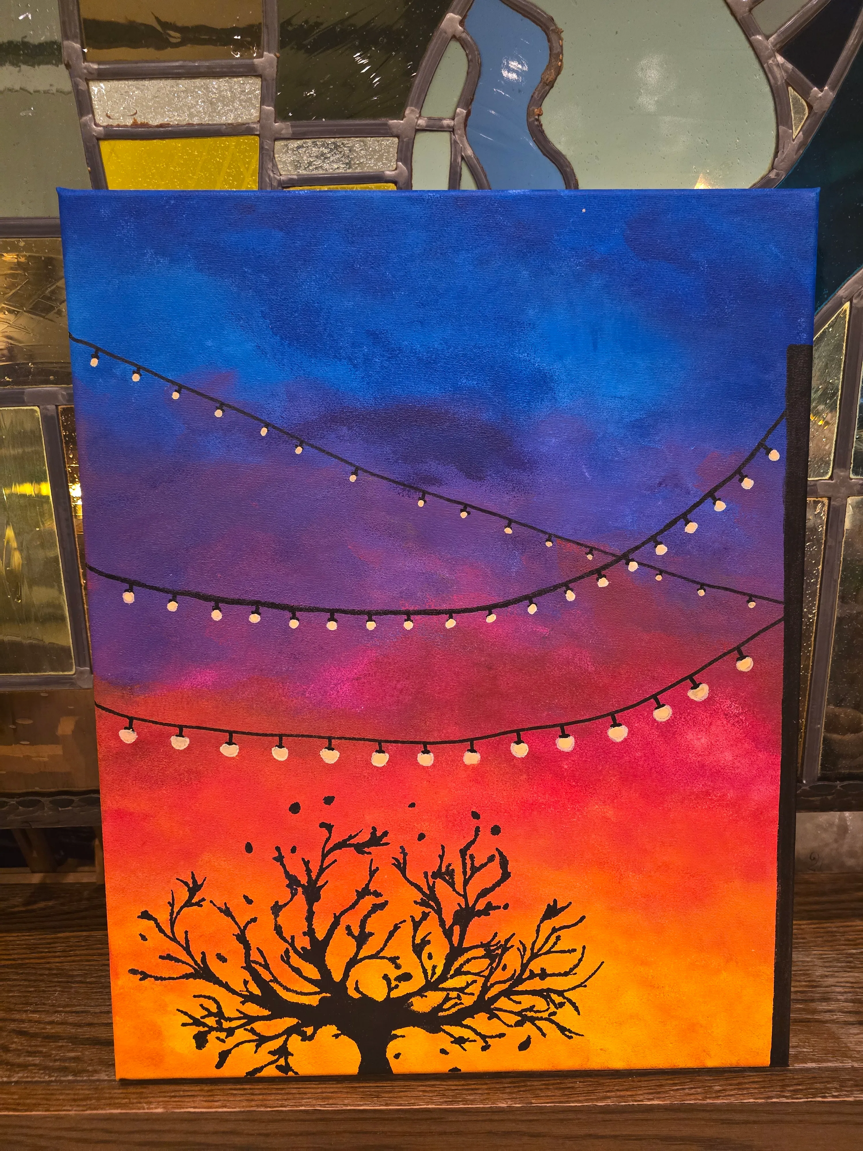 Buntes Sonnenuntergangsbild mit Baum-Silhouette.