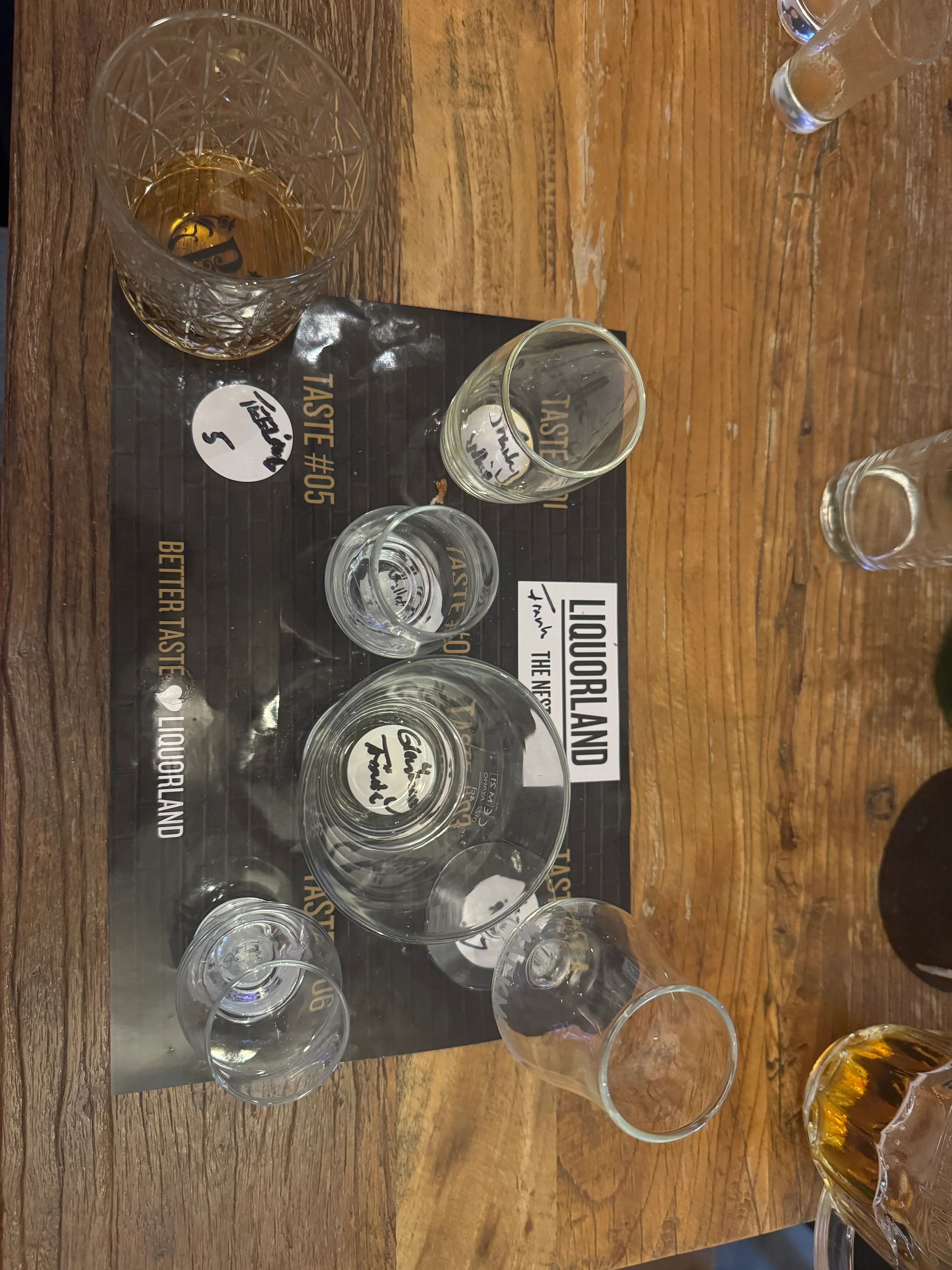 Leere Gläser auf Holztisch mit Beschriftung.