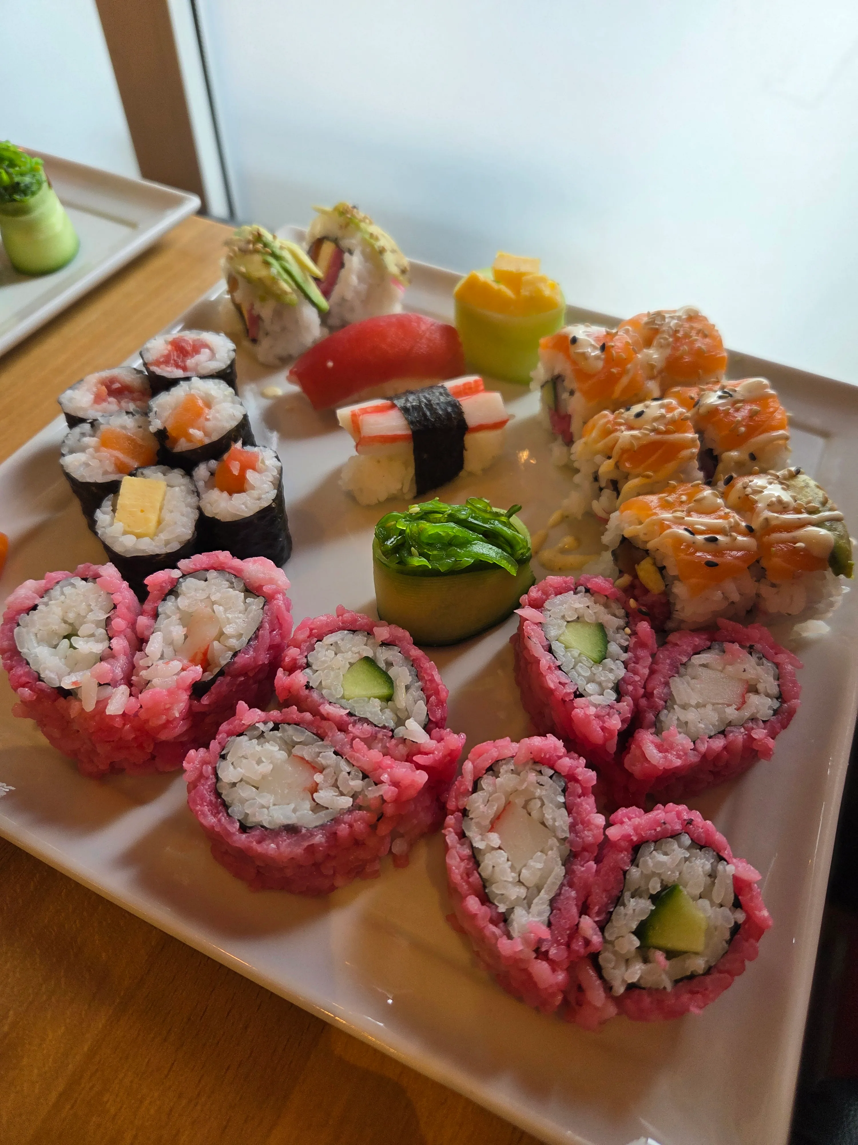 Bunte Sushi-Auswahl auf einem weißen Teller.