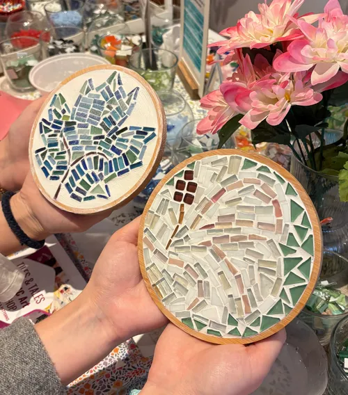 Hand-crafted mosaic art held by two hands.