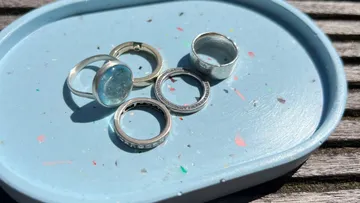 Five silver rings on a blue tray.