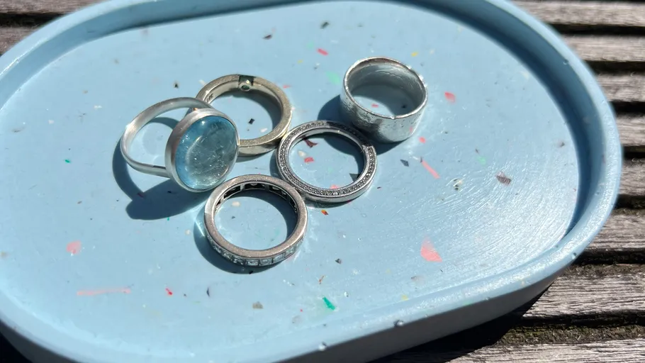Fünf silberne Ringe auf blauem Tablett.