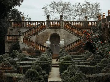 Climb stairs to reach a garden with sculptures.