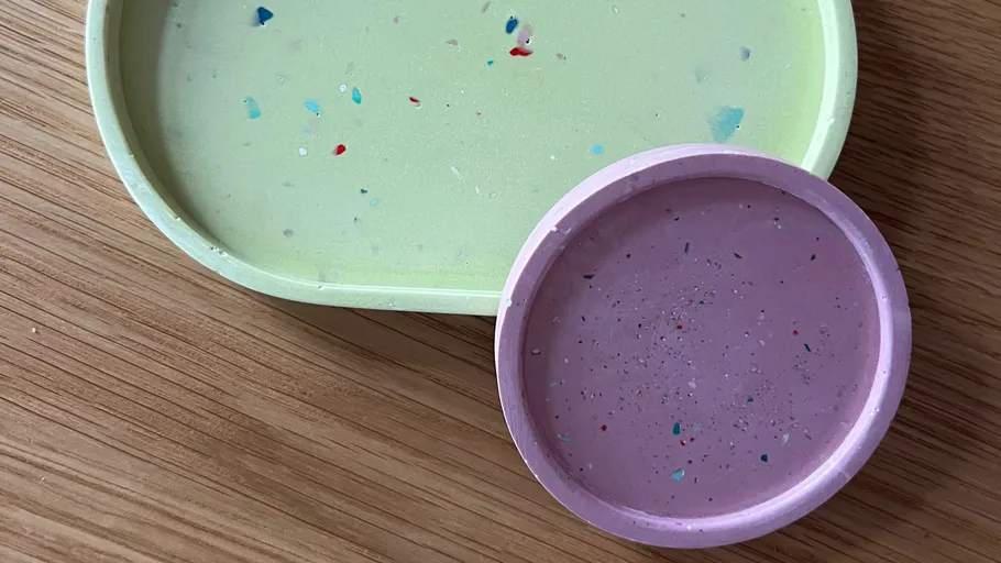 Two speckled trays on a wooden surface.