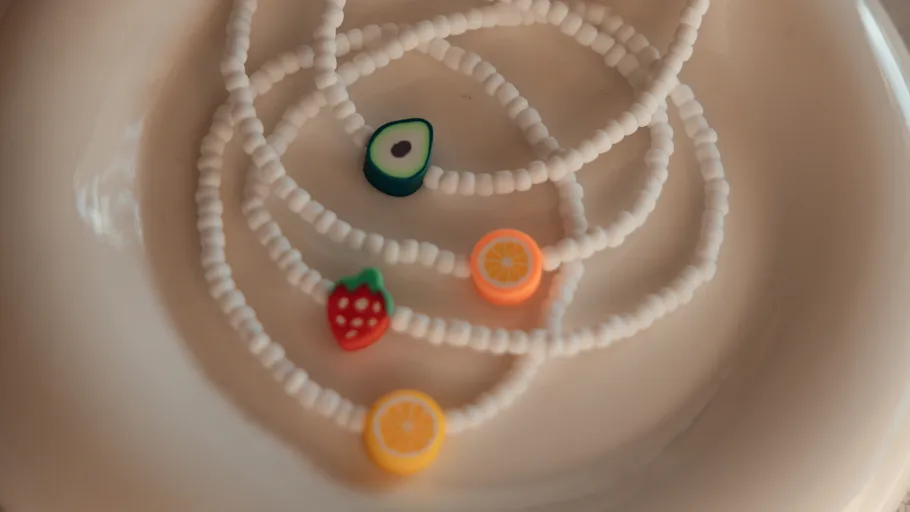 Bunte Fruchtperlen auf weißen Halsketten.