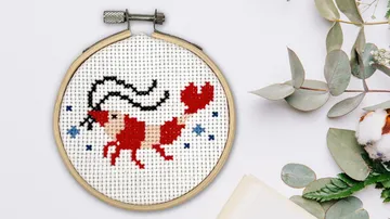Kreuzstich-Widder-Design im Stickrahmen.