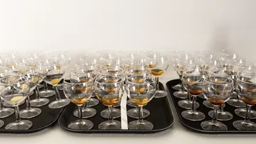 Trays with glasses of amber liquid.