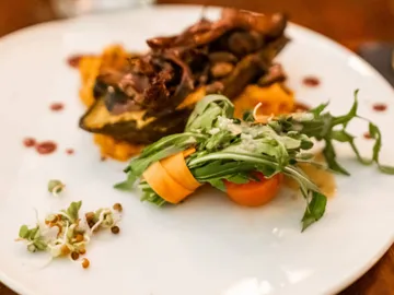 Ein Teller mit Fleisch, Püree und frischem Salat.