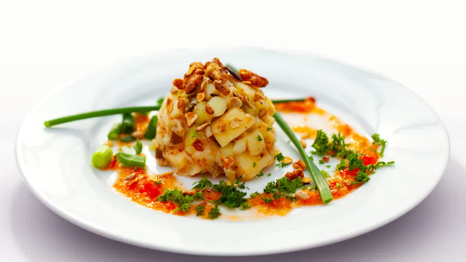 Gourmet dish with nuts and garnish on plate.