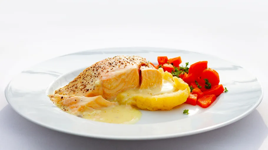 Lachs mit Kartoffelpüree und Karotten auf Teller.