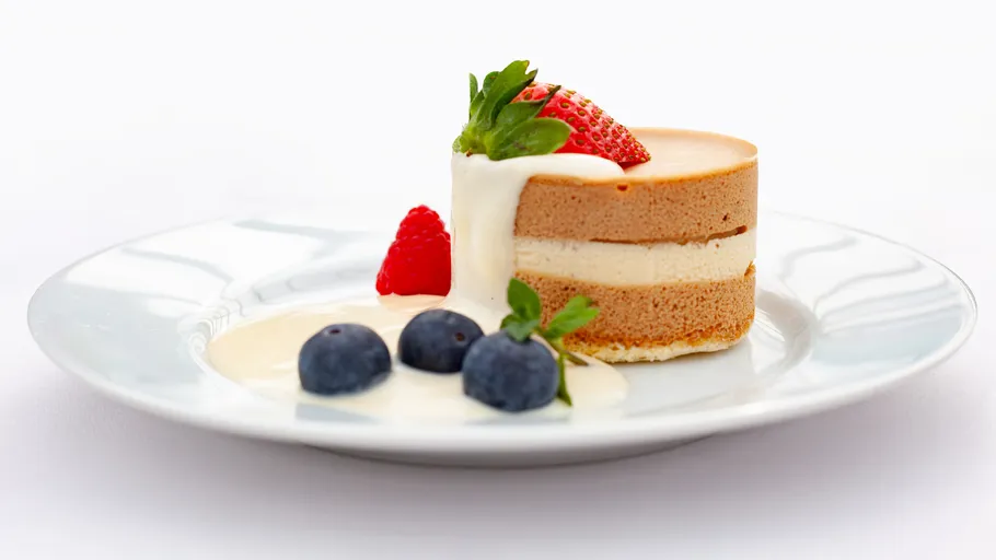 Cheesecake with strawberries and blueberries on plate.