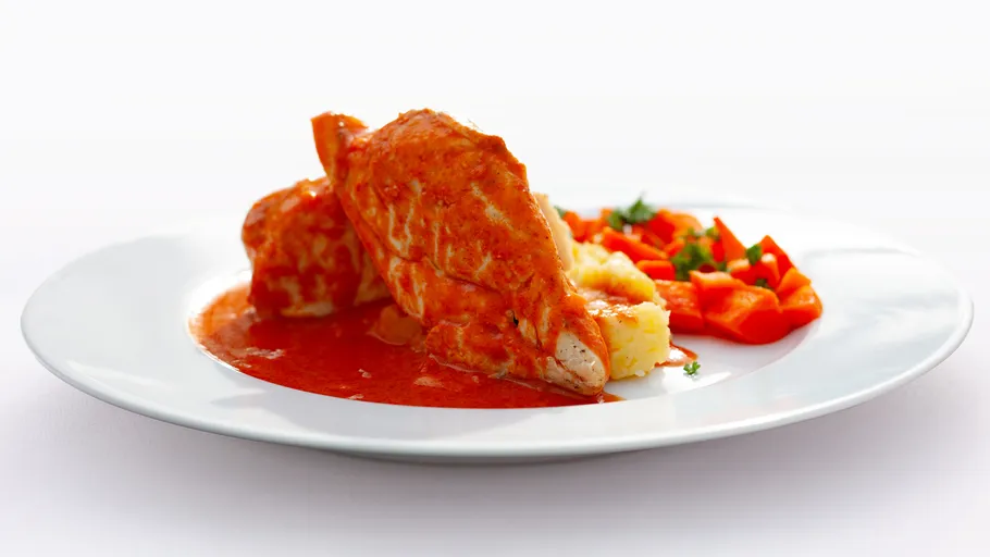 Chicken with red sauce, mashed potatoes, vegetables.