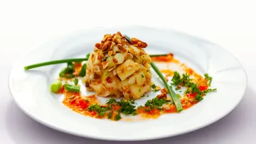 Gourmet salad on white plate with garnish.