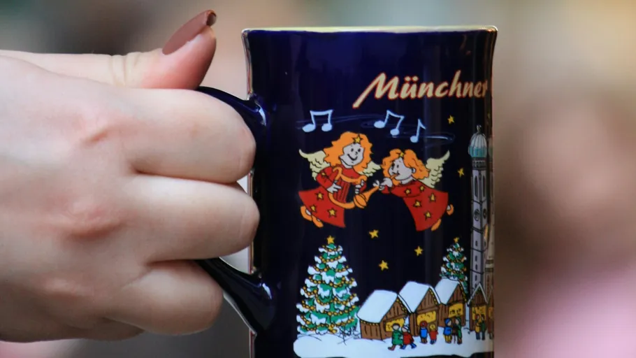 Hand holding decorative Munich Christmas mug.