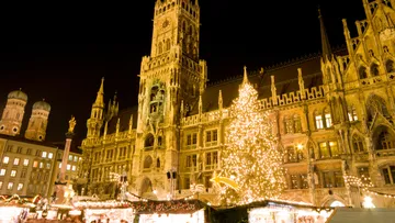 Festive Christmas market in front of illuminated building.