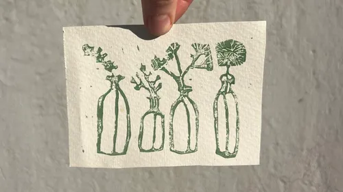Hand holding card with green plant prints.