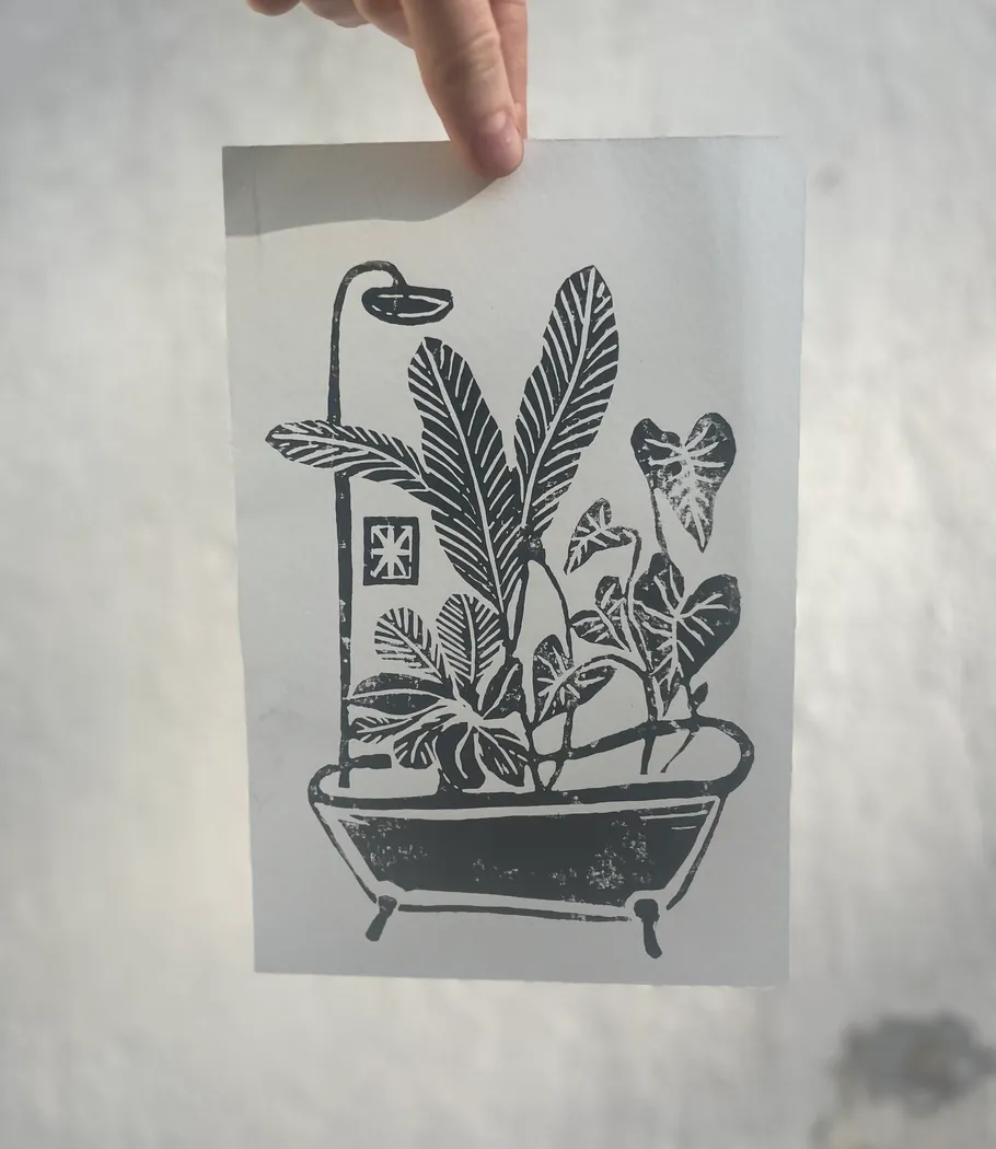Black-and-white plant illustration held by a hand.