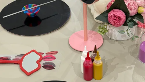 Cosmetic supplies and pink flowers on a table.