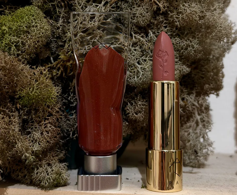 Lipstick and gloss tubes in mossy setting.