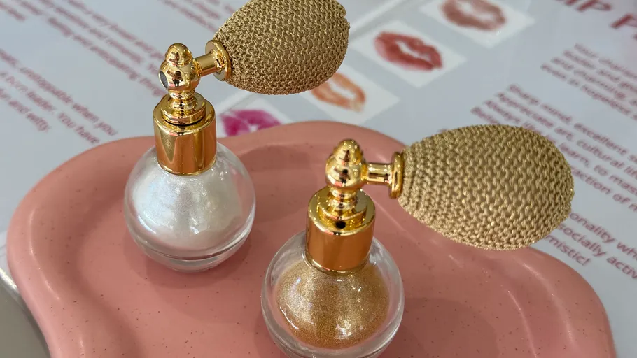 Zwei Glitzerflaschen auf rosa Tablett.