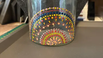 Glass jar with colorful dotted pattern.