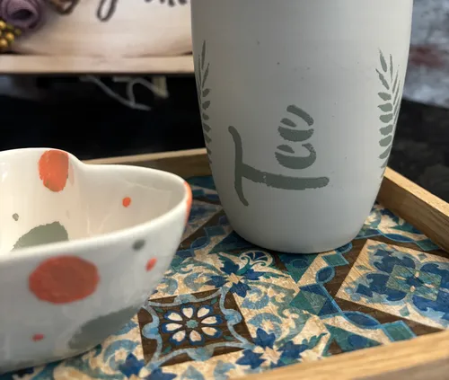 Decorative cups on colorful patterned tray.