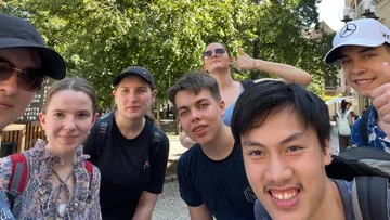 Gruppe junger Menschen lächelt im Freien.